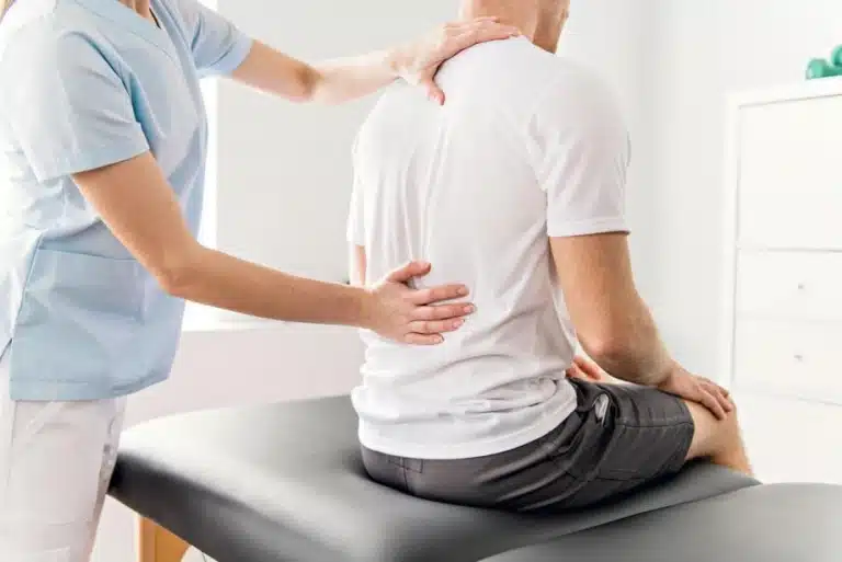 Physiotherapist assessing a patient with back pain